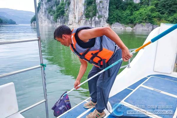 邓生华打捞斯拉河漂浮物 本报通讯员 陈婷 摄